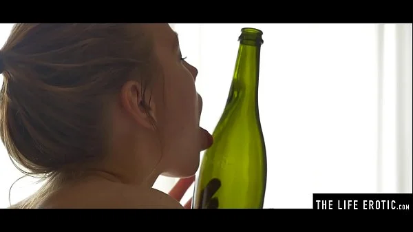 Horny teen fucks her tight shaved pussy with an empty wine bottle